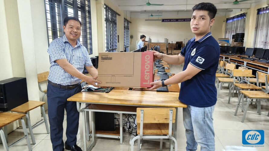 Đại diện tiếp nhận bộ máy tính Lenovo tại một điểm trường trong dự án Quỹ Thiện Tâm năm 2026